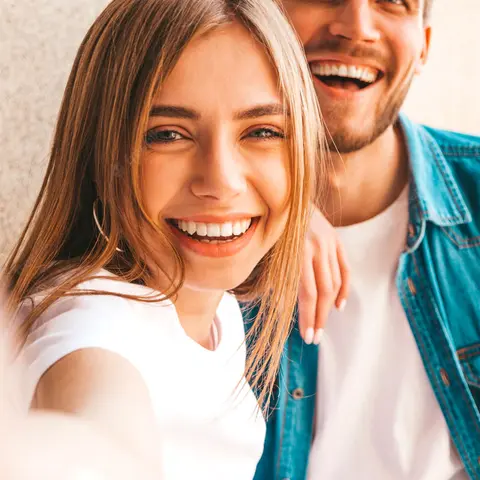 Un couple souriant se prend en selfie pendant ses vacances